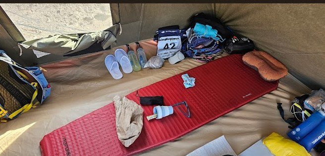Tent with organised kit, race bib 42, water bottles lined up